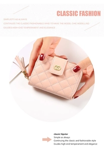 Close-up of light pink quilted wallet with golden ring logo and leather tassel zipper