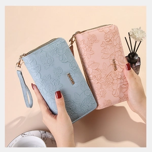 Close-up of floral embossed long wallets in blue and pink with double zippers and wristlet