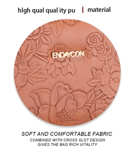 Detailed macro view of brown PU leather with embossed floral texture and metal logo