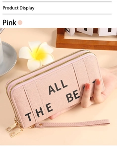 Detail of pink long wallet with litchi texture, double zippers and wrist strap