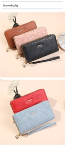 Detail of floral embossed texture and dual zipper design on a long women's clutch wallet