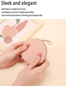 Petit porte-monnaie rond en cuir rose avec fermeture éclair dorée et crochet métallique