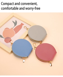 Gros plan de trois porte-monnaie ronds en cuir gris, bleu et rouge avec zip doré
