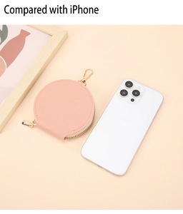 Mini porte-monnaie en cuir rose avec zip doré à côté d'un iPhone pour comparer la taille