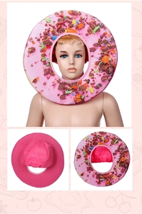 Detail showing plush pink donut hat with colorful sprinkles and soft velvet texture