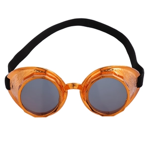 Detail of steampunk goggles featuring orange-gold carved frames and dark round lenses