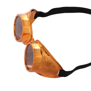 Detail of steampunk goggles with orange-gold gear carvings and black elastic strap