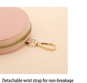 Détail de la fermeture éclair dorée et du crochet sur le petit porte-monnaie rond en cuir