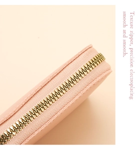 Detail of pink card holder featuring texture leather and precision electroplated gold zipper