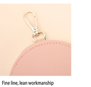 Vue détaillée du porte-monnaie en cuir rose avec coutures fines et crochet doré