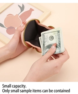 Gros plan d'un mini porte-monnaie en cuir rose montrant le rangement des billets