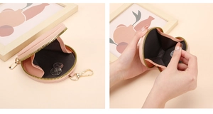 Détail du porte-monnaie rond rose en cuir avec fermeture éclair dorée et crochet métal