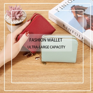 Detail of red and light cyan dual-zipper leather wallets on wooden table with magazines
