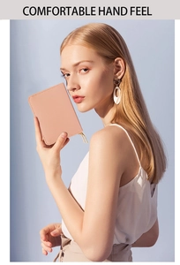 Detail of peach pink lychee grain leather wallet featuring dual golden metal zippers