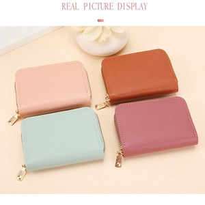 Close-up of four colored leather card holders with gold zippers in a flat lay view
