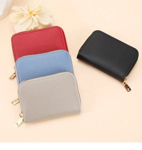Top view of compact leather card holders in red, blue, grey, and black with gold zippers