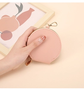 Gros plan détaillé d'un porte-monnaie rond en cuir rose avec fermeture éclair dorée