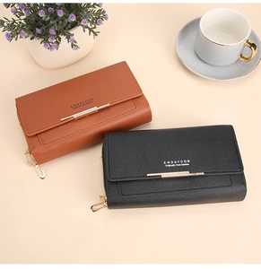 Detail view of long leather wallets in black and brown with golden metal accents