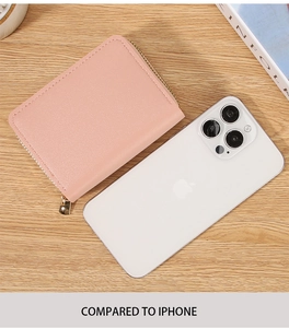 Pink zippered accordion card holder size comparison with an iPhone on wooden surface