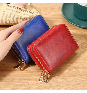 Macro shot of dual zipper card holders in vibrant red and blue on a wooden table