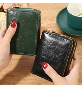 Close-up of dual zipper oil wax leather card holders in dark green and black colors