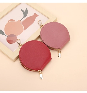Détail des porte-monnaie en cuir rouge et rose avec fermetures éclair et crochets dorés