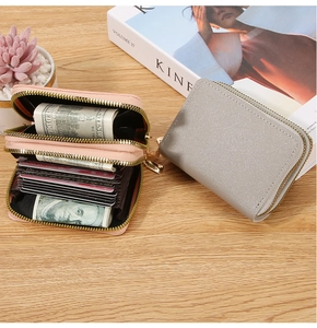 Close-up of double zipper accordion card wallet featuring multiple slots and pink leather