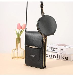 Close-up of black leather crossbody phone bag with gold hardware and small round pouch