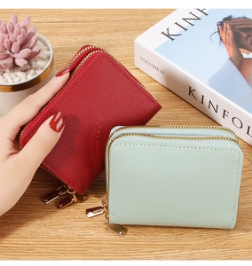 Close-up of red and mint green lychee pattern card wallets with double gold zippers