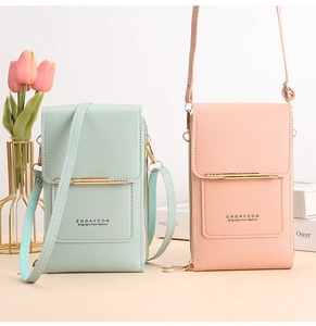 Detailed view of mint green and light pink touchscreen crossbody phone bags with gold trim
