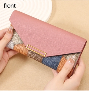 Close-up of multi-color patchwork long wallet with premium metal buckle held by hand