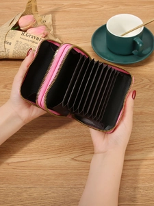 Pink double zipper RFID card holder wallet with accordion slots on a wooden desk