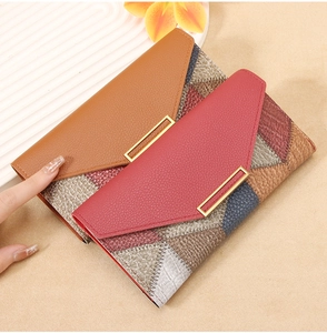 Detail of color-block wallet with textured patchwork and golden metallic buckle