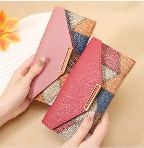 Detail of color-block long wallet featuring litchi texture and gold metal buckle
