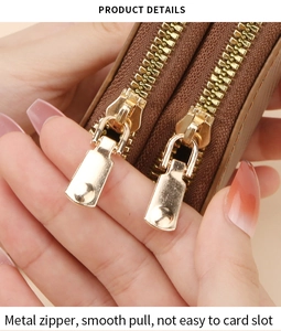 Detail of a brown leather wallet featuring two gold metal zippers and a smooth gliding design