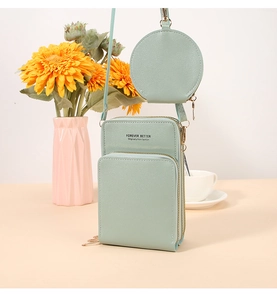 Dettaglio borsa porta cellulare verde menta con tre zip e ciondolo portamonete rotondo
