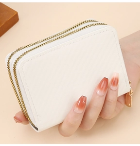 Close-up of white textured leather double-zipper wallet with gold-tone hardware detail
