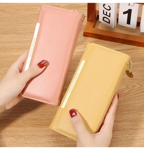 Close-up of pink and yellow long leather wallets with gold metal accents and wrist straps
