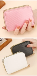Close-up of dual-zipper credit card wallets in pink and black carbon fiber texture