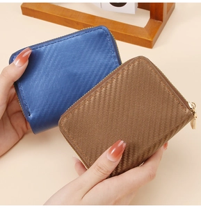 Close-up of blue and brown carbon fiber texture card wallets with gold metal zippers