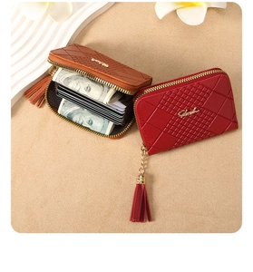 Detail of short leather wallet with lattice embossing, multiple card slots and tassel