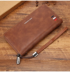 Dettaglio portafoglio lungo marron con trama in pelle e cinturino a righe classiche