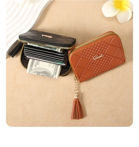 Detail of zip accordion card holder with quilted pattern and tassel charm in two colors