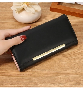 Detail of a long black wallet for women with gold logo bar and pink lining interior