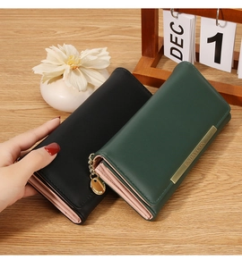 Detail of bifold long wallets in black and green showing card slots and pink lining