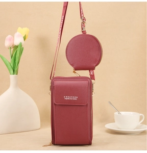 Detalle de la bolsa vertical roja para móvil con monedero redondo y correa ajustable