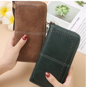 Detail of vintage RFID long wallets in brown and green with hollow-out stitching and wristlets