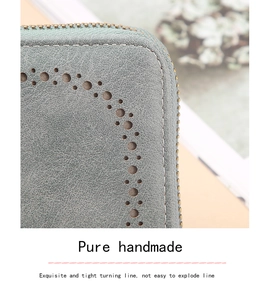Close-up of pure handmade stitching and laser-cut hollow details on grey leather wallet