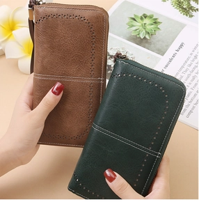 Detail of vintage RFID leather wallets in brown and green with hollow punch patterns