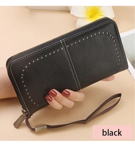 Detailed view of black litchi leather wallet with hollow cutout design and wrist strap